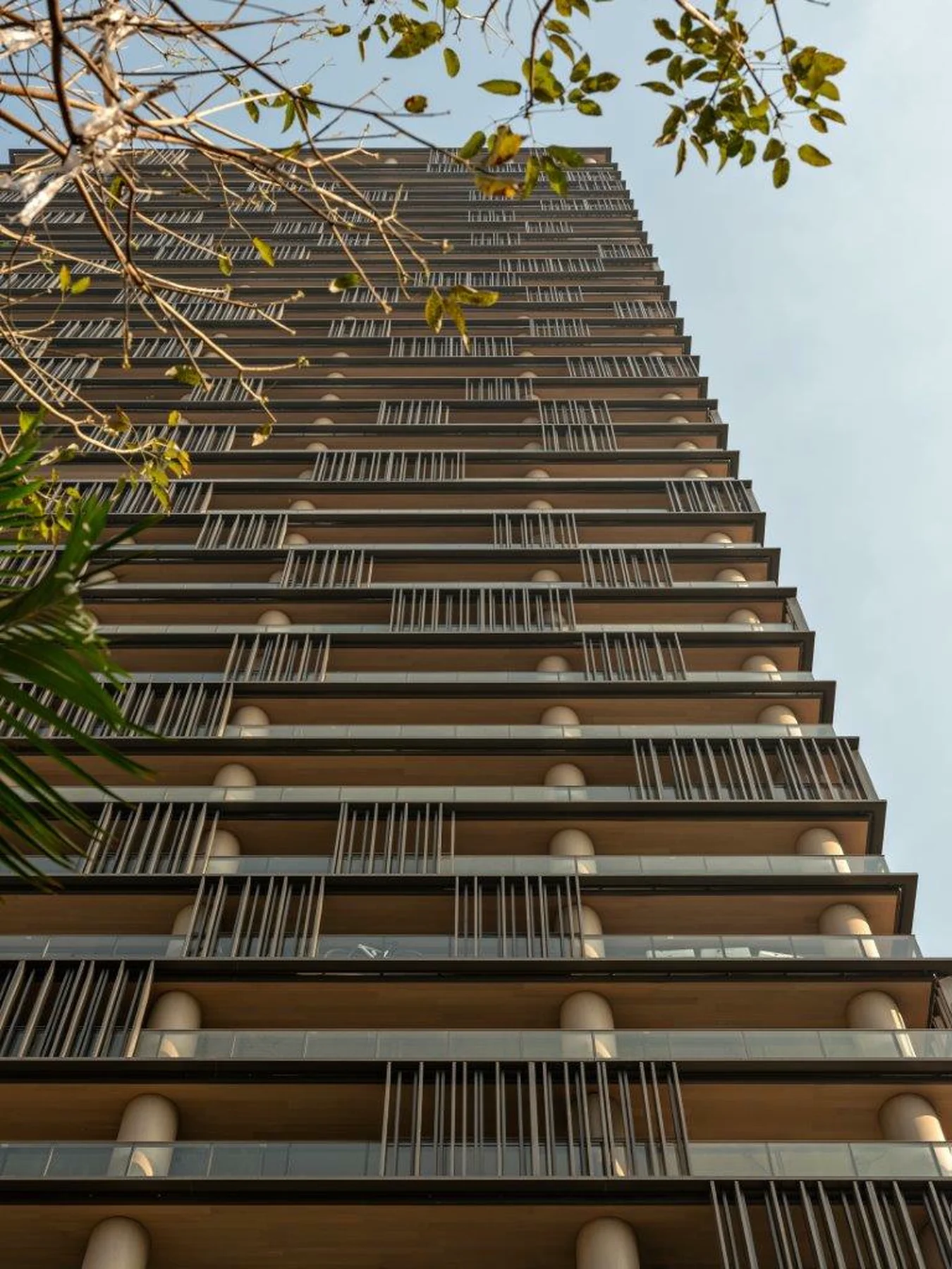 Detalhe da fachada do Praça Henrique Monteiro, com varandas corridas e brises verticais